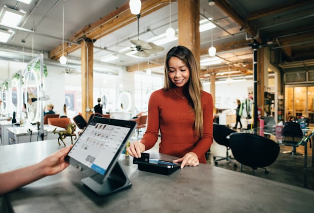 Independent retailer completing a customer sale at a shop counter